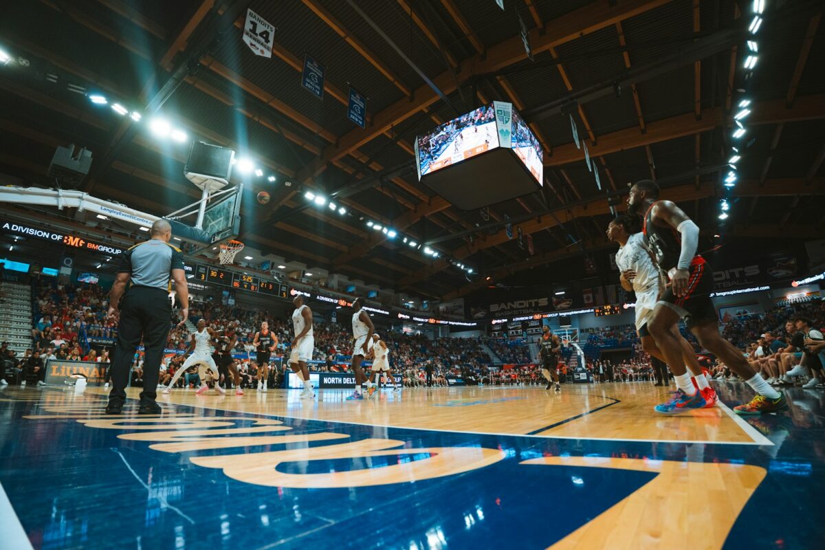 Basketball players compete during a game in an arena.